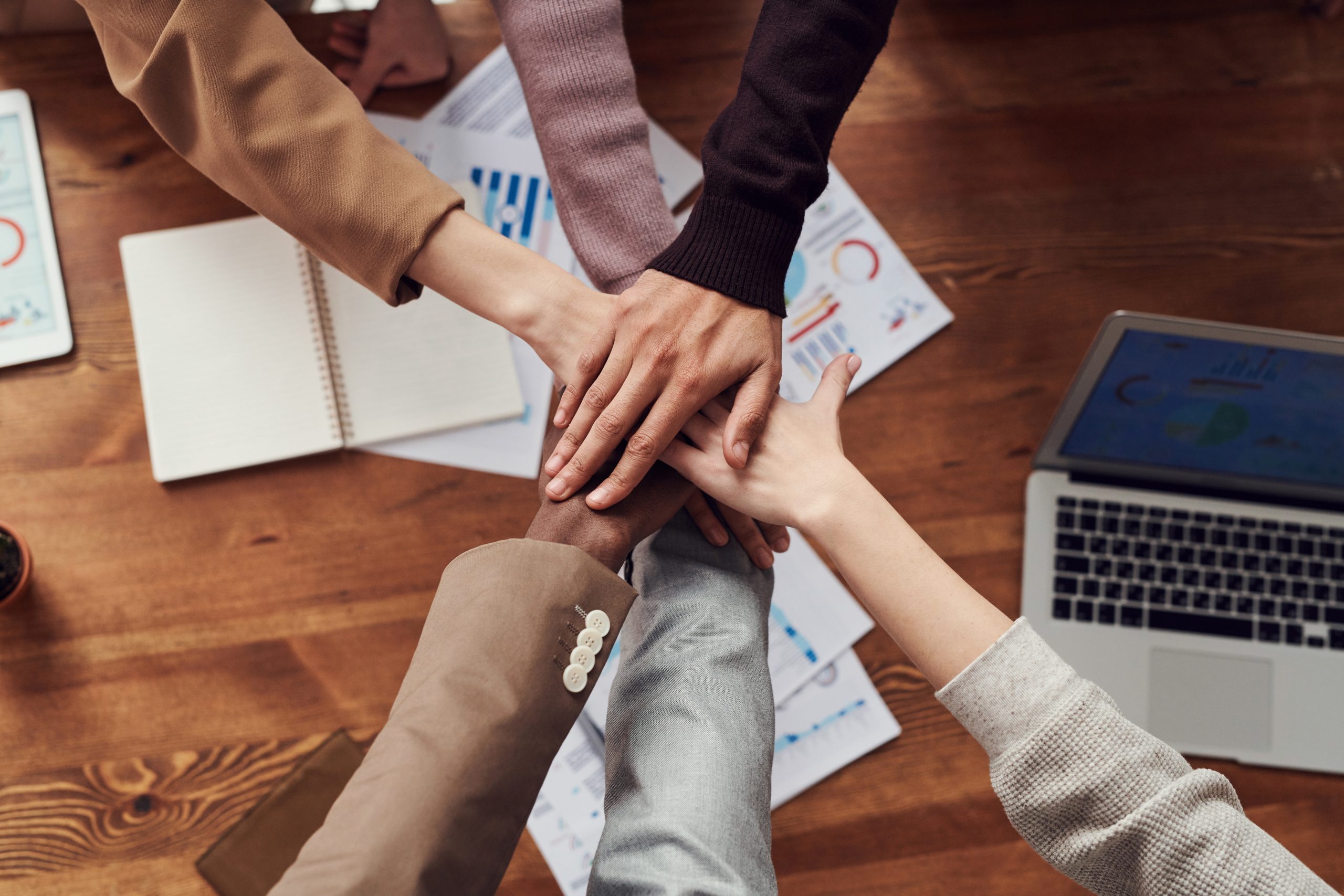 hands together over a meeting table