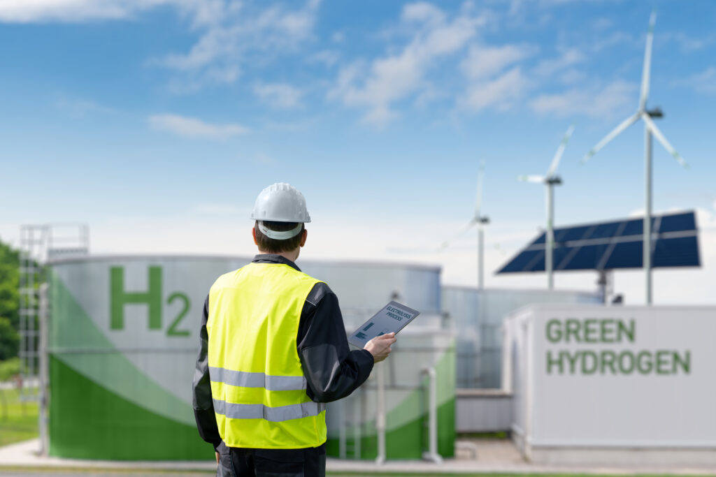 Engineer with tablet computer on a background of Hydrogen factory