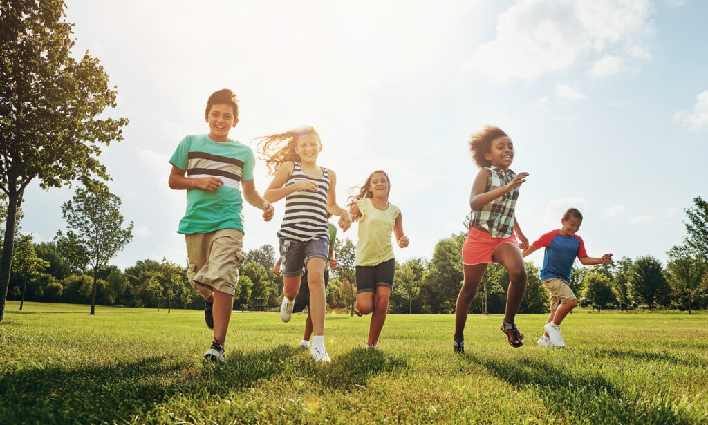 Five kids running in a park