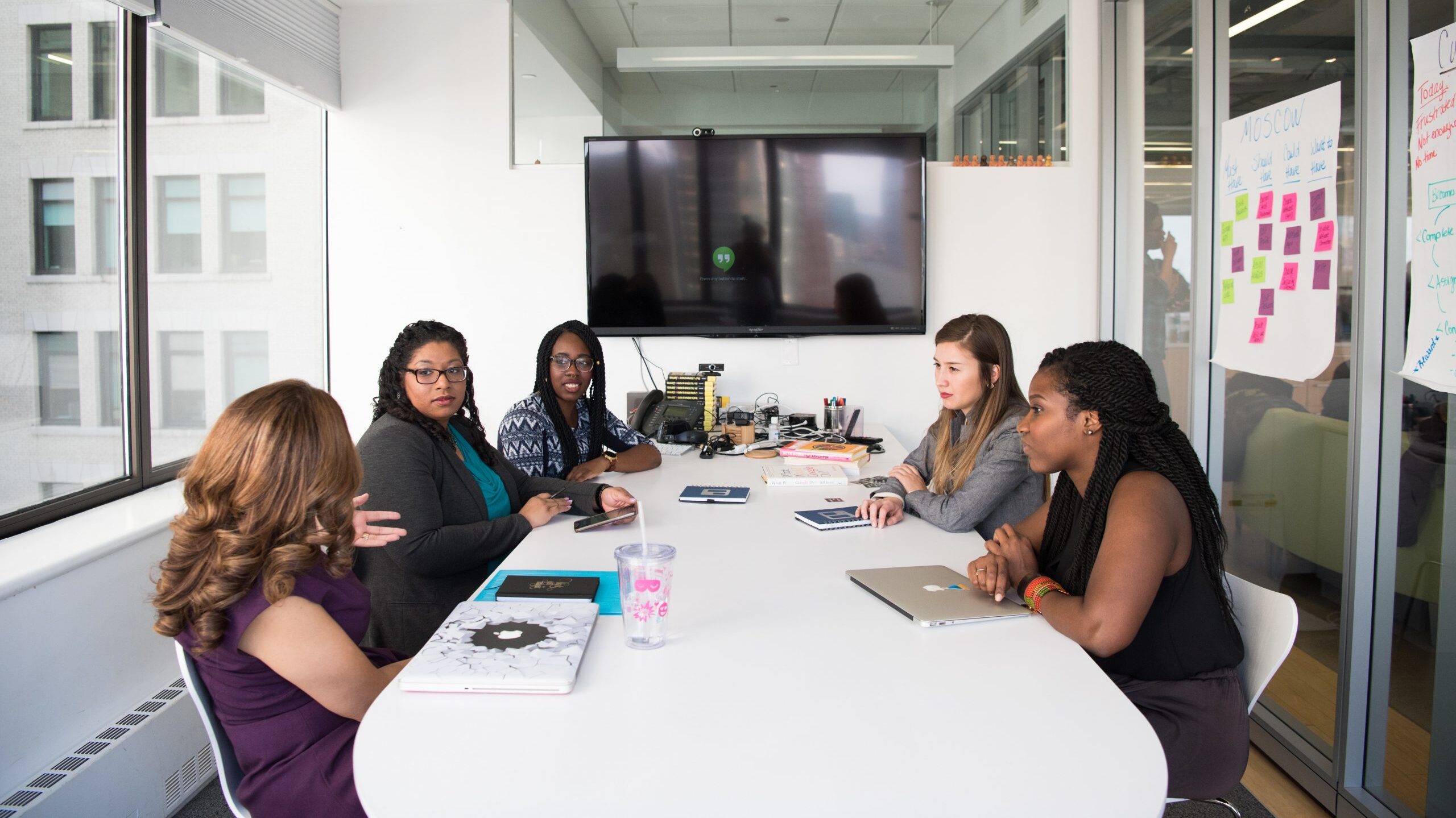 five women meeting at a conference room table